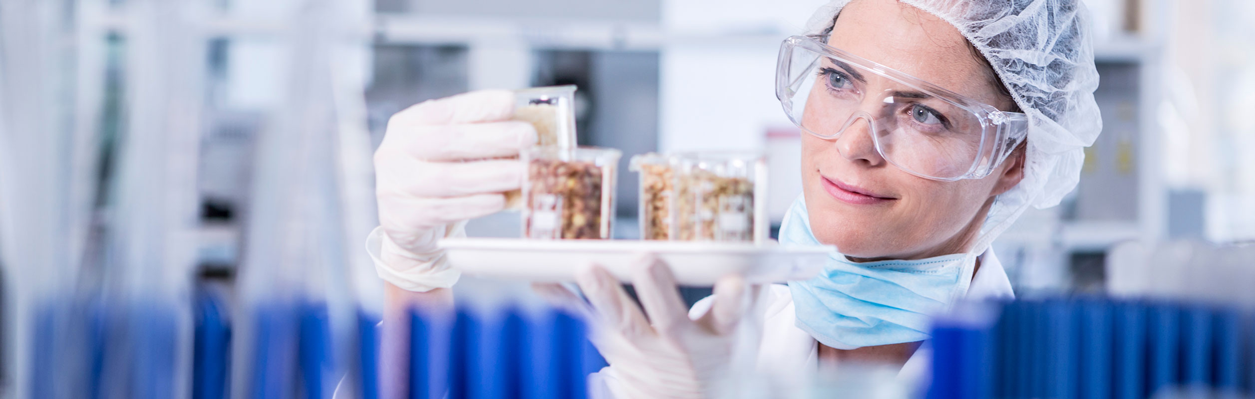 photo of a lab technitian looking at a vial