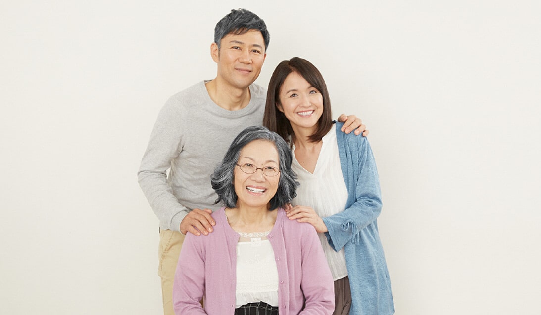 一名年轻男子、一名妇女和一名年长妇女微笑的照片
