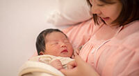 photo of a mother cuddling an infant