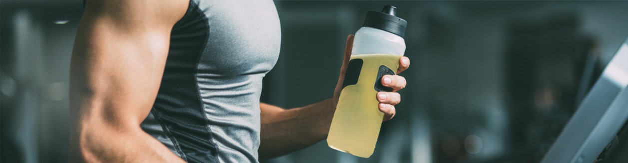 Photo of a man exercising with a protein shaker in his hand