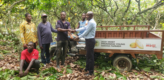 Awarded farmer (center), hauling harvested cocoa
