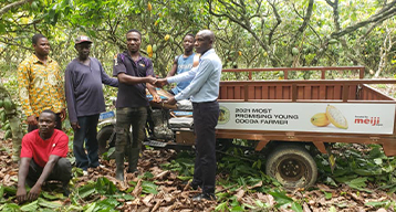 Awarded farmer (center), hauling harvested cocoa