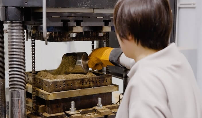 photo of forming cacao husk powder into shapes by applying heat and pressure